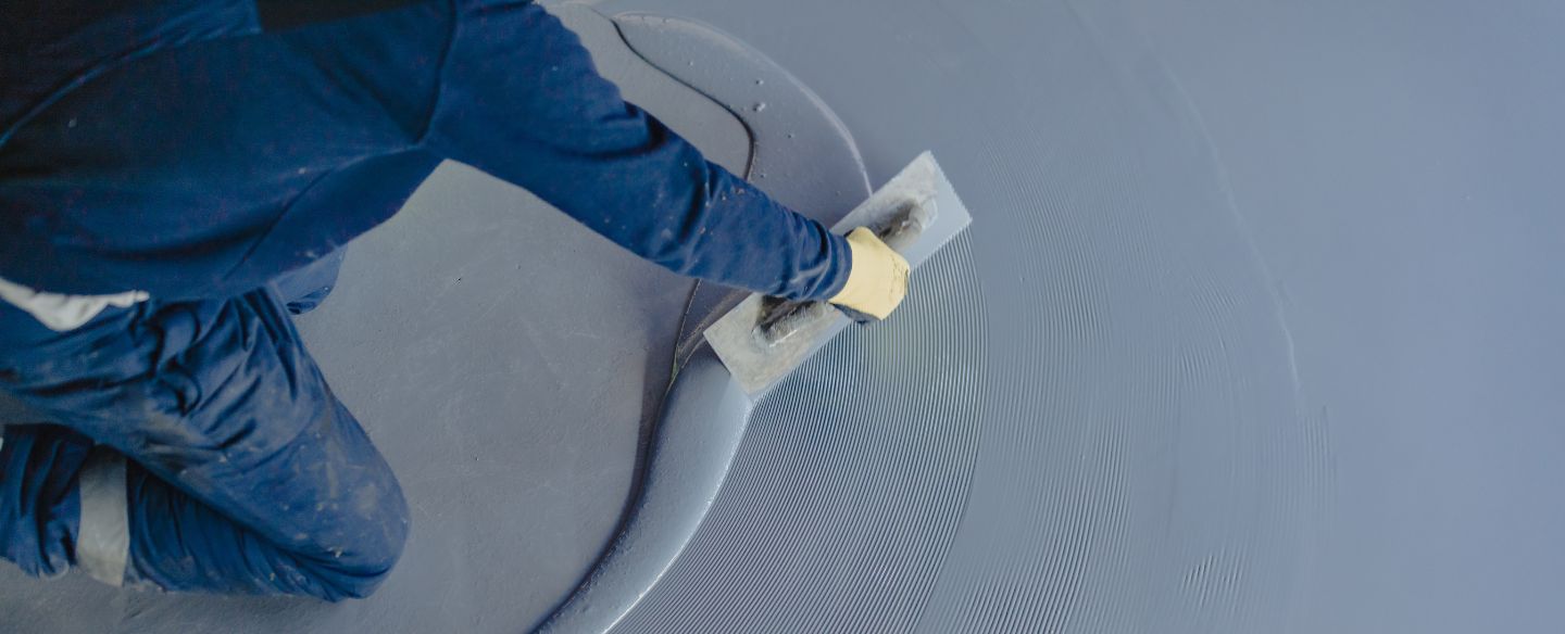 worker applying gray epoxy resin to floor lehigh acres fl